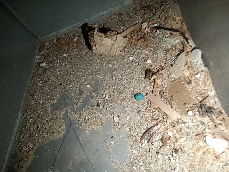 Construction debris, wood chips, and trash found inside a return plenum before duct cleaning.