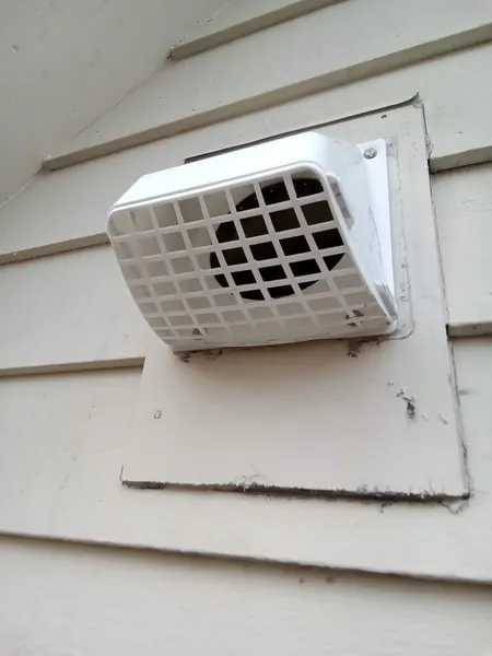 The same dryer vent hood clear of lint after cleaning, with airflow fully restored.