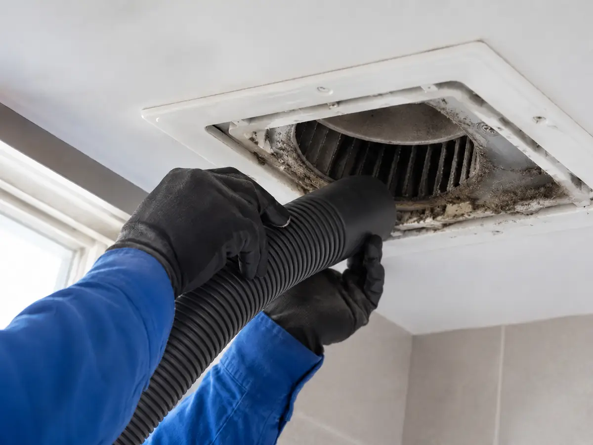 Armstrong technician cleaning a bath exhaust fan and duct
