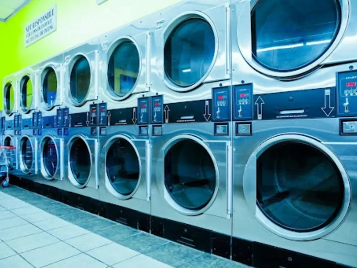 Row of commercial dryers with freshly cleaned vent ducts in a commercial laundry