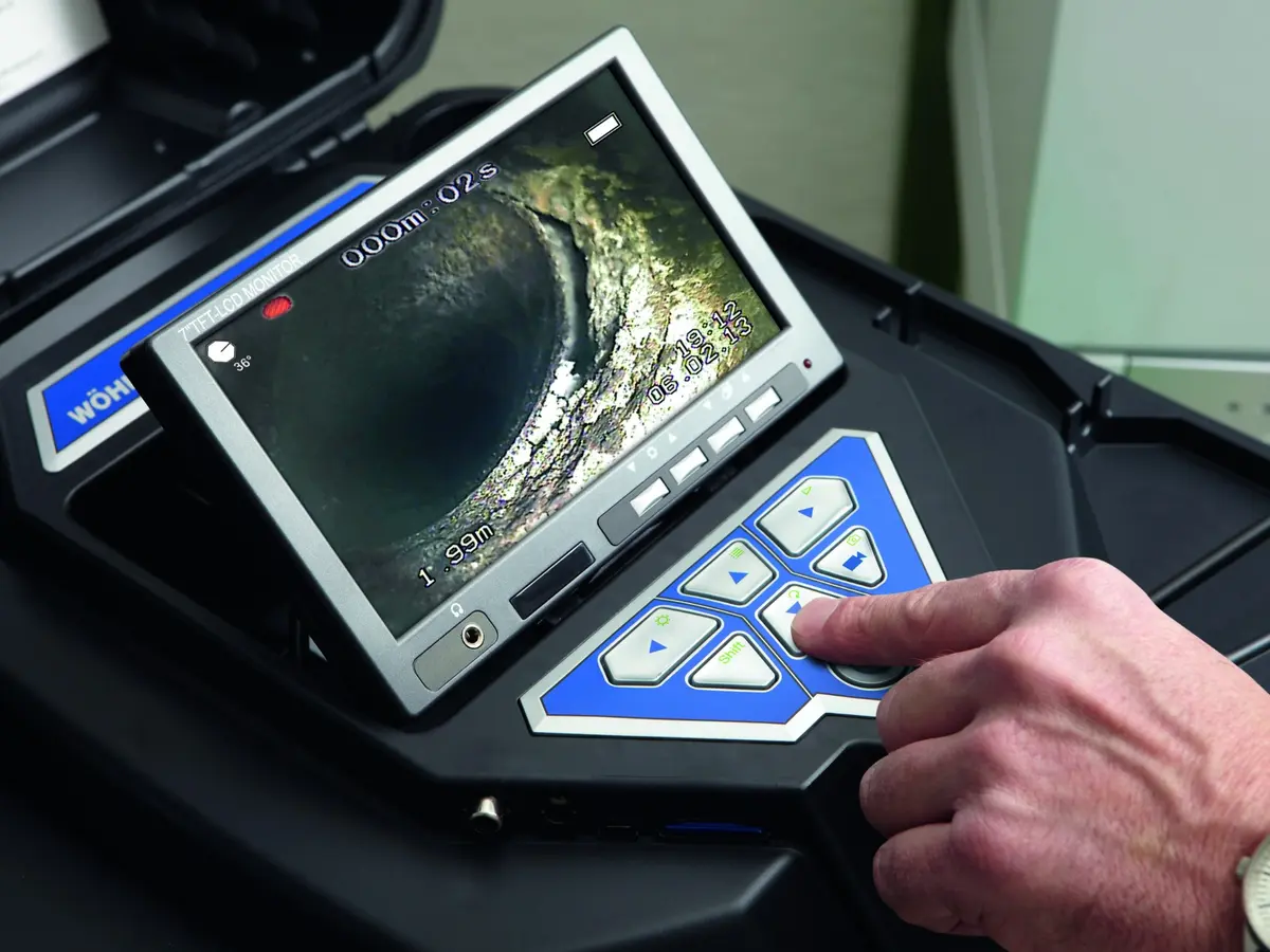 Armstrong technician guiding a video inspection camera through commercial ductwork